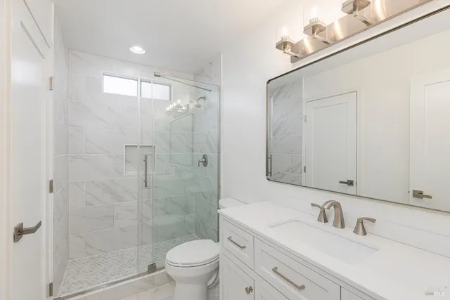 a bathroom with a sink a toilet and shower