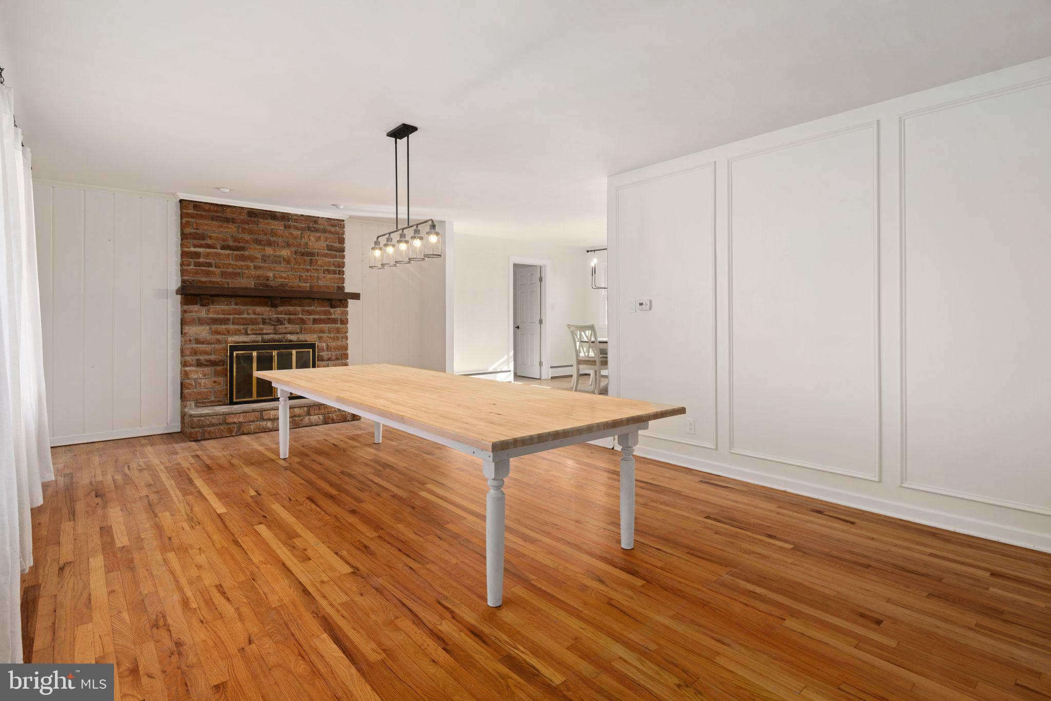 2003 West Rock Road Perkasie, PA 18944 - Photo 3 of 32 a living room with kitchen island dining table wooden floor and a chandelier