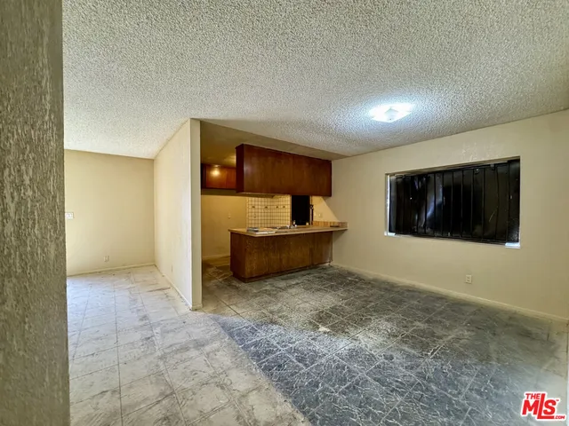 a view of an empty room with a cabinet and a window