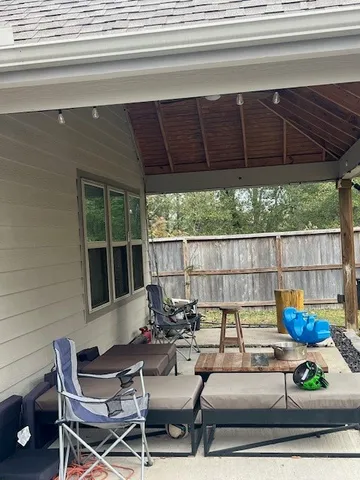 a view of a backyard with a small cabin and wooden fence