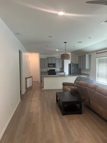 a living room with furniture a kitchen and a fireplace