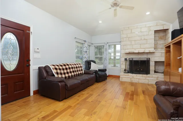 a living room with furniture a flat screen tv and kitchen view