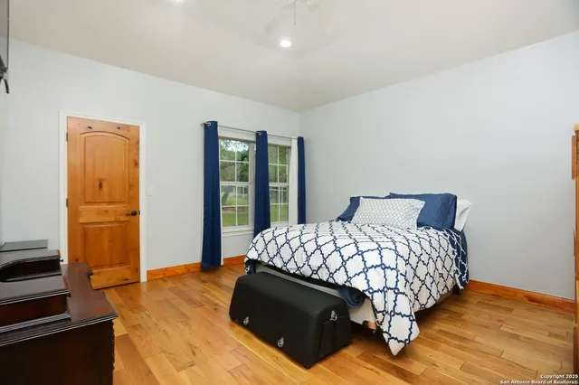 a bedroom with a bed and a flat tv screen on the dresser