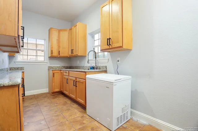 a kitchen with granite countertop a sink and cabinets