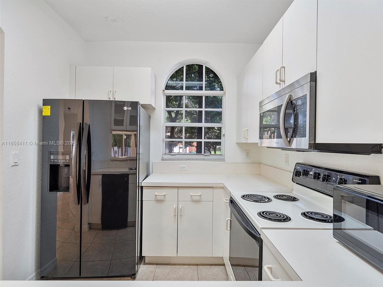 4964 Southwest 128th Avenue Miramar, FL 33027 - Photo 12 of 38 a kitchen with stainless steel appliances a stove a refrigerator and a sink