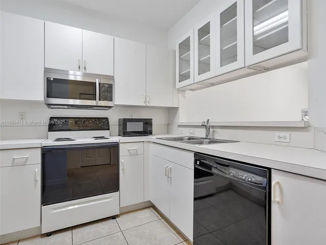 a kitchen with cabinets stainless steel appliances and a sink