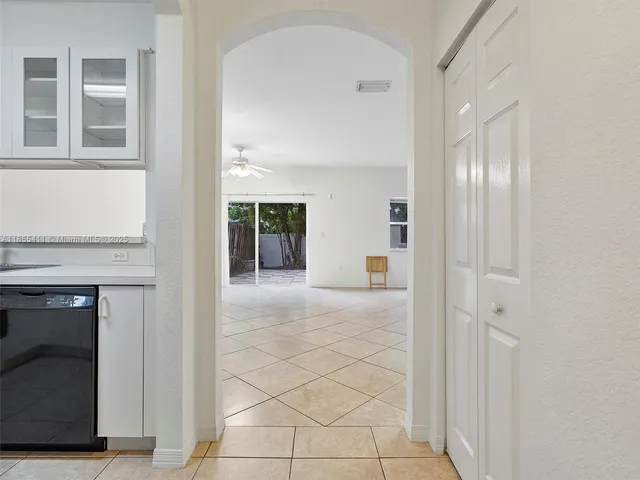 a view of a hallway with wooden cabinets