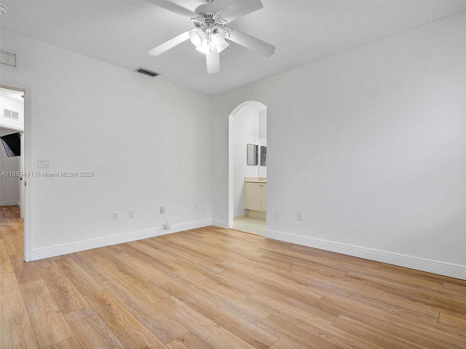 4964 Southwest 128th Avenue Miramar, FL 33027 - Photo 17 of 38 an empty room with wooden floor fan and windows