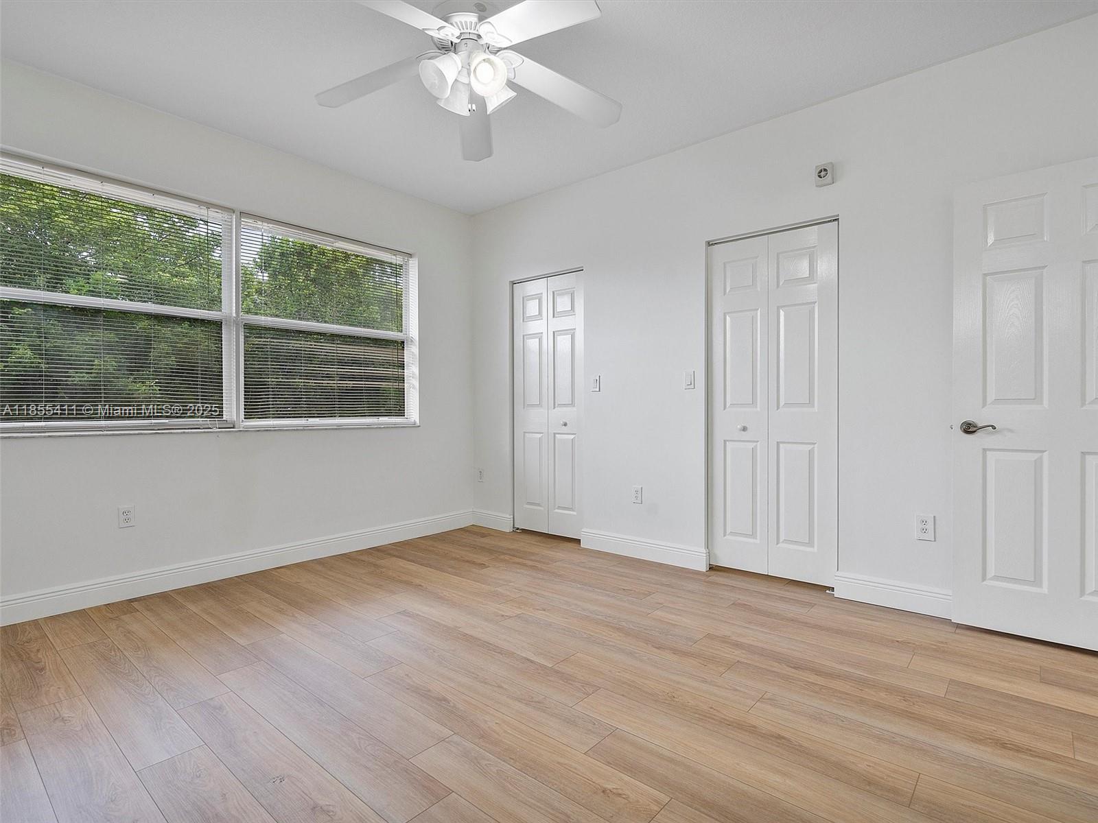4964 Southwest 128th Avenue Miramar, FL 33027 - Photo 19 of 38 a view of an empty room with wooden floor and a window