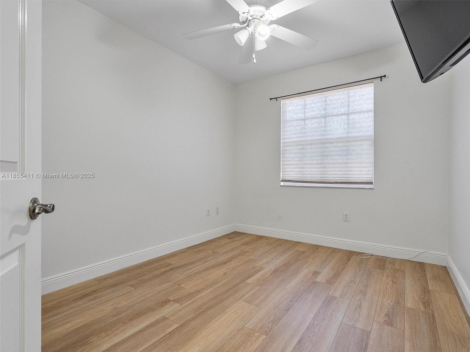 4964 Southwest 128th Avenue Miramar, FL 33027 - Photo 28 of 38 an empty room with wooden floor fan and windows
