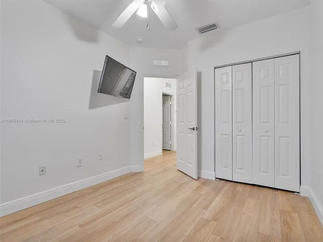 a view of a livingroom with wooden floor and a ceiling fan