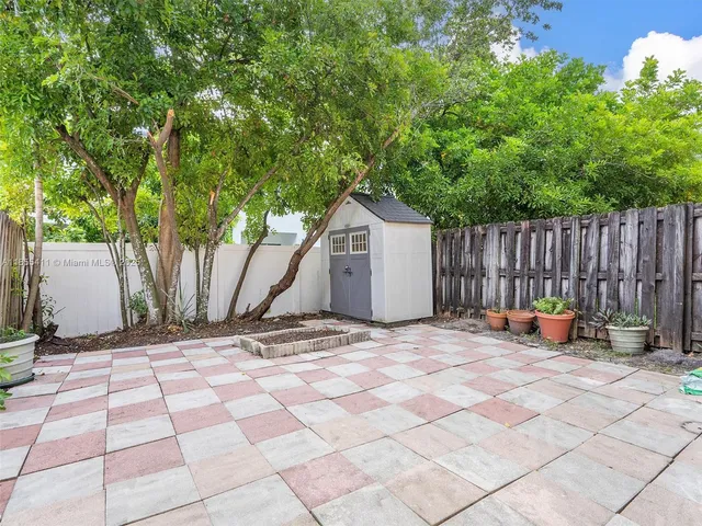 a view of backyard with wooden fence and a large tree