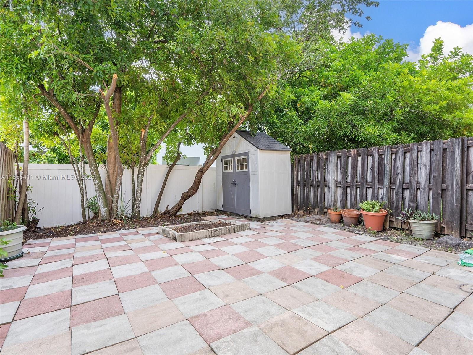 4964 Southwest 128th Avenue Miramar, FL 33027 - Photo 34 of 38 a view of backyard with wooden fence and a large tree