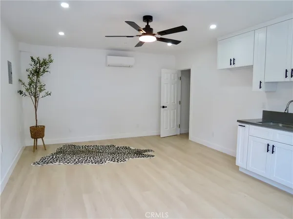 a kitchen with white cabinets and sink