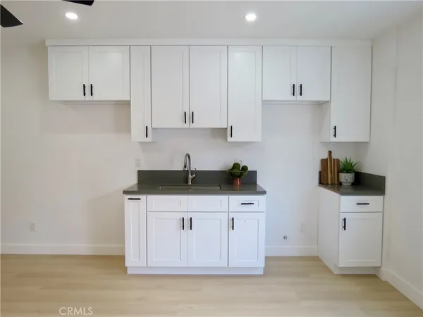 a kitchen with granite countertop a sink cabinets stainless steel appliances and a window