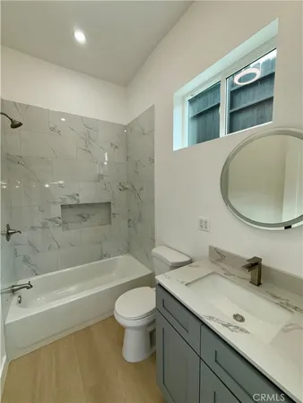 a bathroom with a granite countertop sink a toilet and bathtub