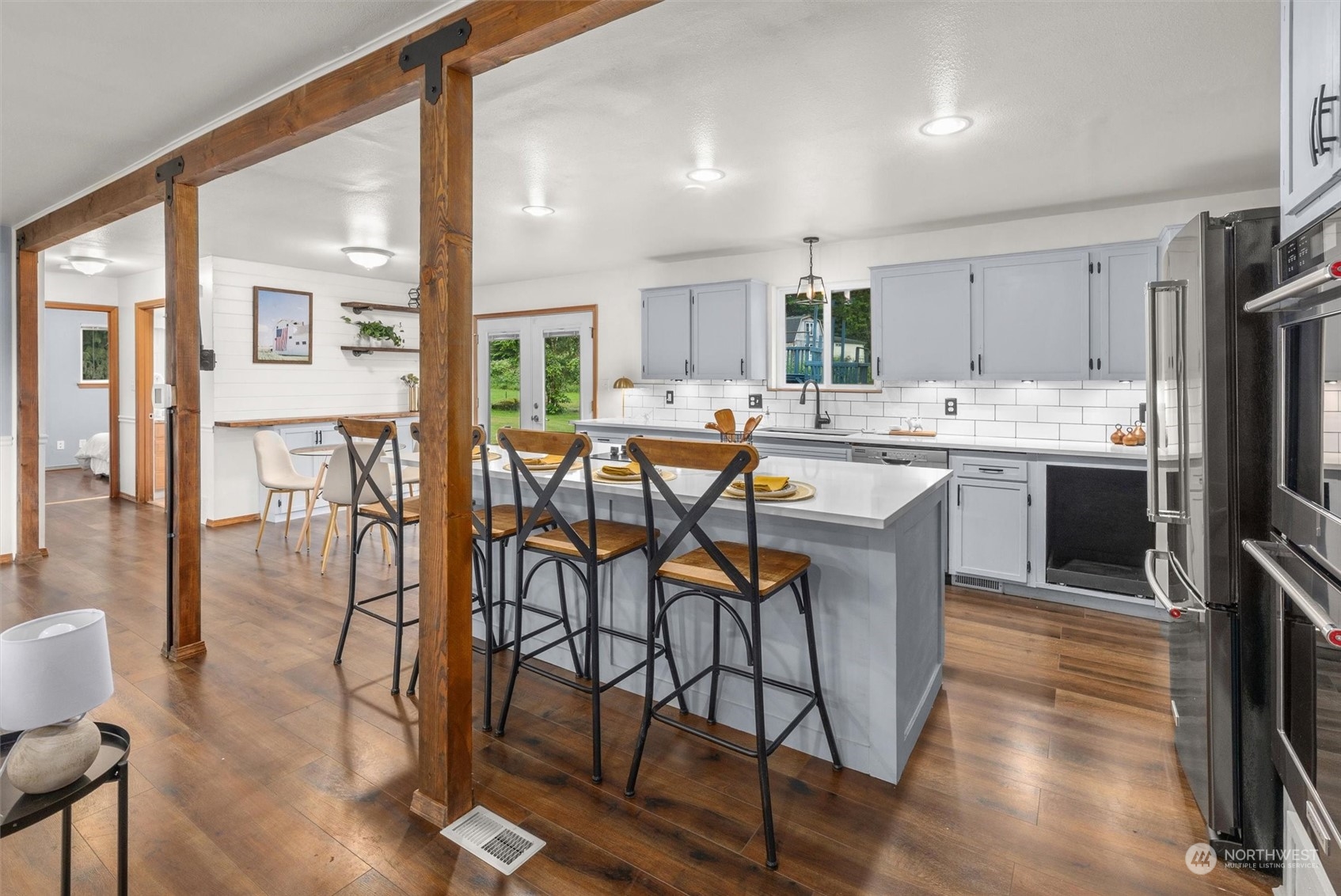 14220 Three Lakes Road Snohomish, WA 98290 - Photo 8 of 31 a kitchen with stainless steel appliances a table chairs refrigerator and cabinets