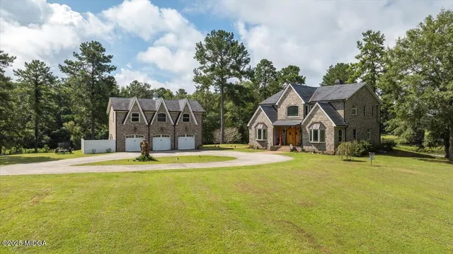 a front view of house with yard and trees in the background
