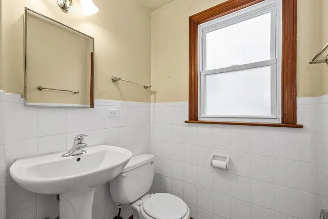 a bathroom with a toilet sink and mirror