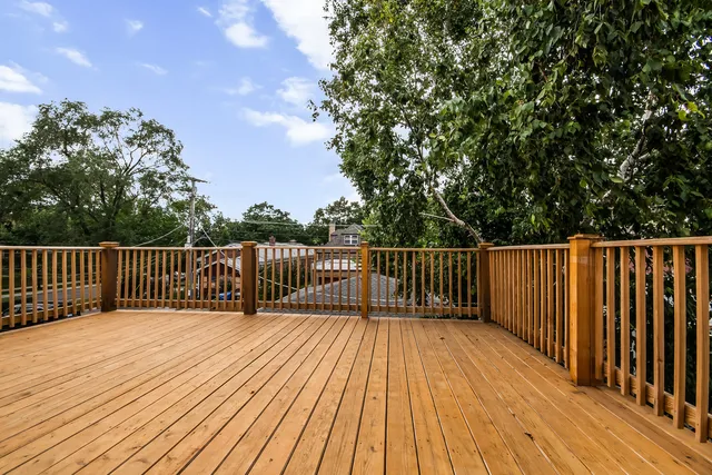 a balcony with wooden floor and fence