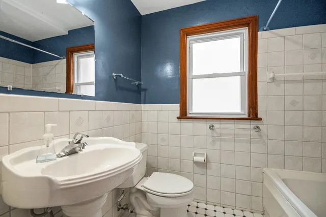 a bathroom with a sink a toilet and mirror