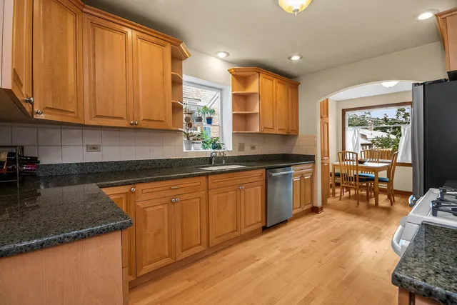 a kitchen with granite countertop a sink stove and cabinets