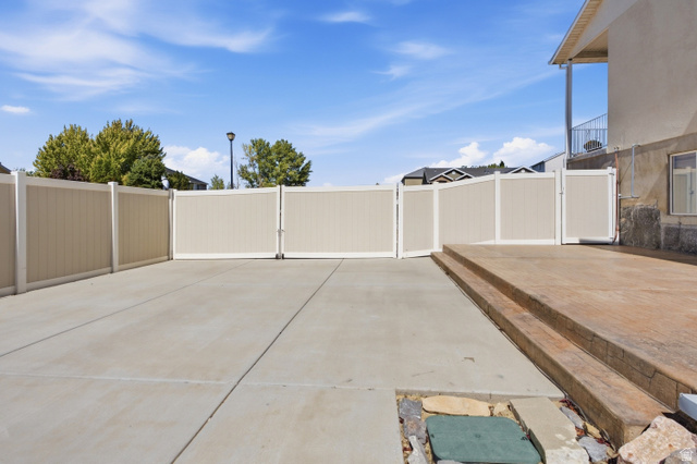 926 Ibis Way Draper, UT 84020 - Photo 30 of 41 Fully fenced and huge gate opening up to RV parking, a space for a boat, ATVs or use it for a sports court or family parties. Colored and stamped concrete, extra electrical outlets and access to brand new solar inverter.