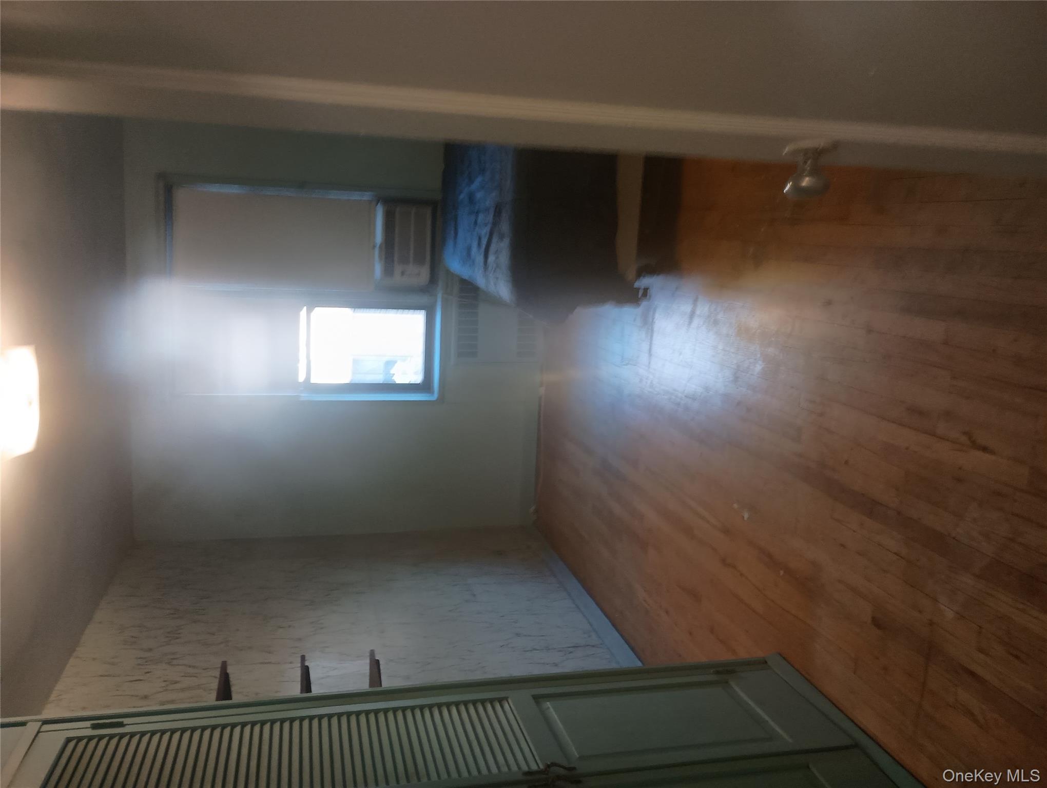 3655 Shore Parkway, Unit 4C Brooklyn, NY 11235 - Photo 4 of 9 a view of an empty room with wooden floor and a window