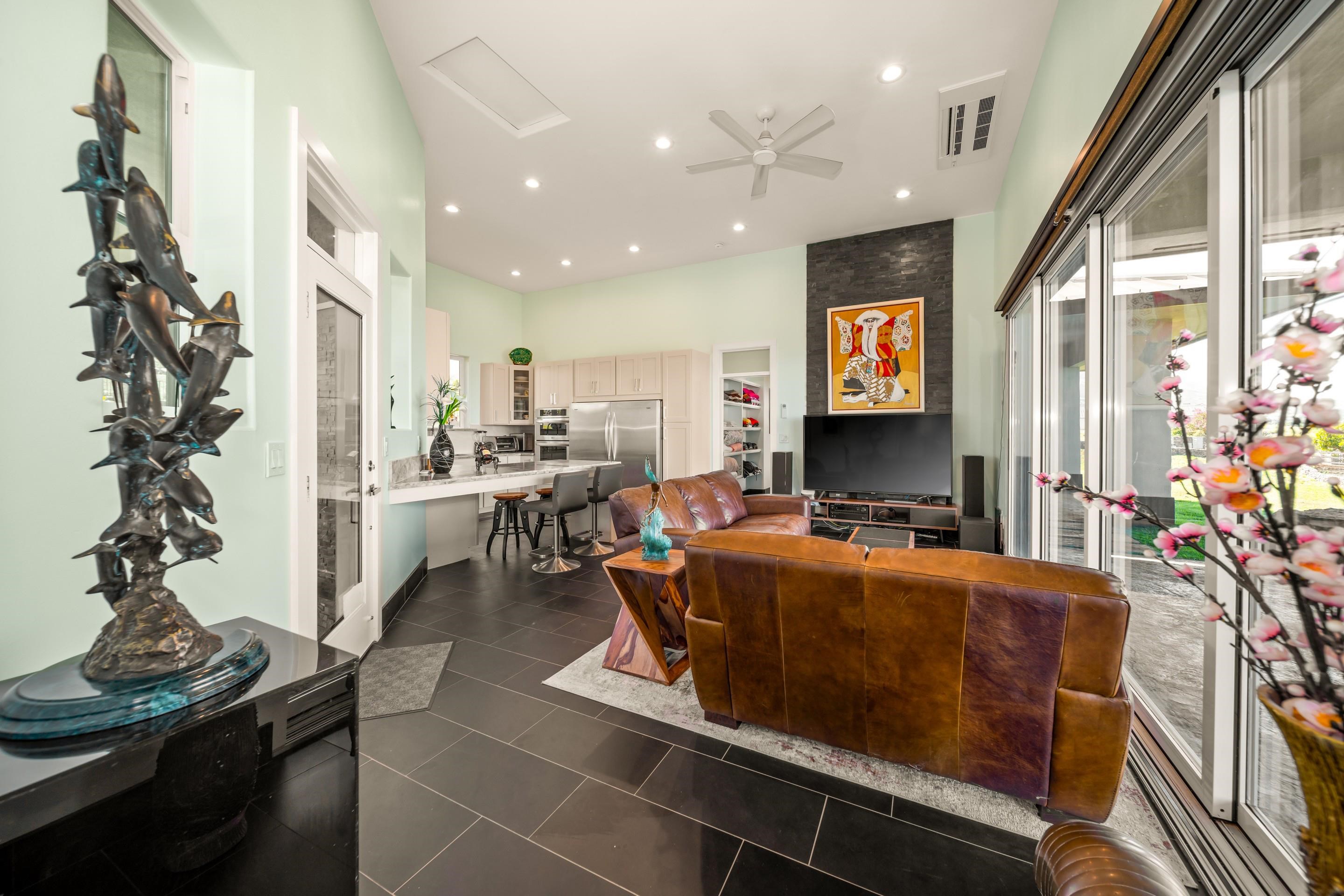 272 Huahua Street Kula, HI 96790 - Photo 11 of 43 a living room with furniture a flat screen tv and a chandelier