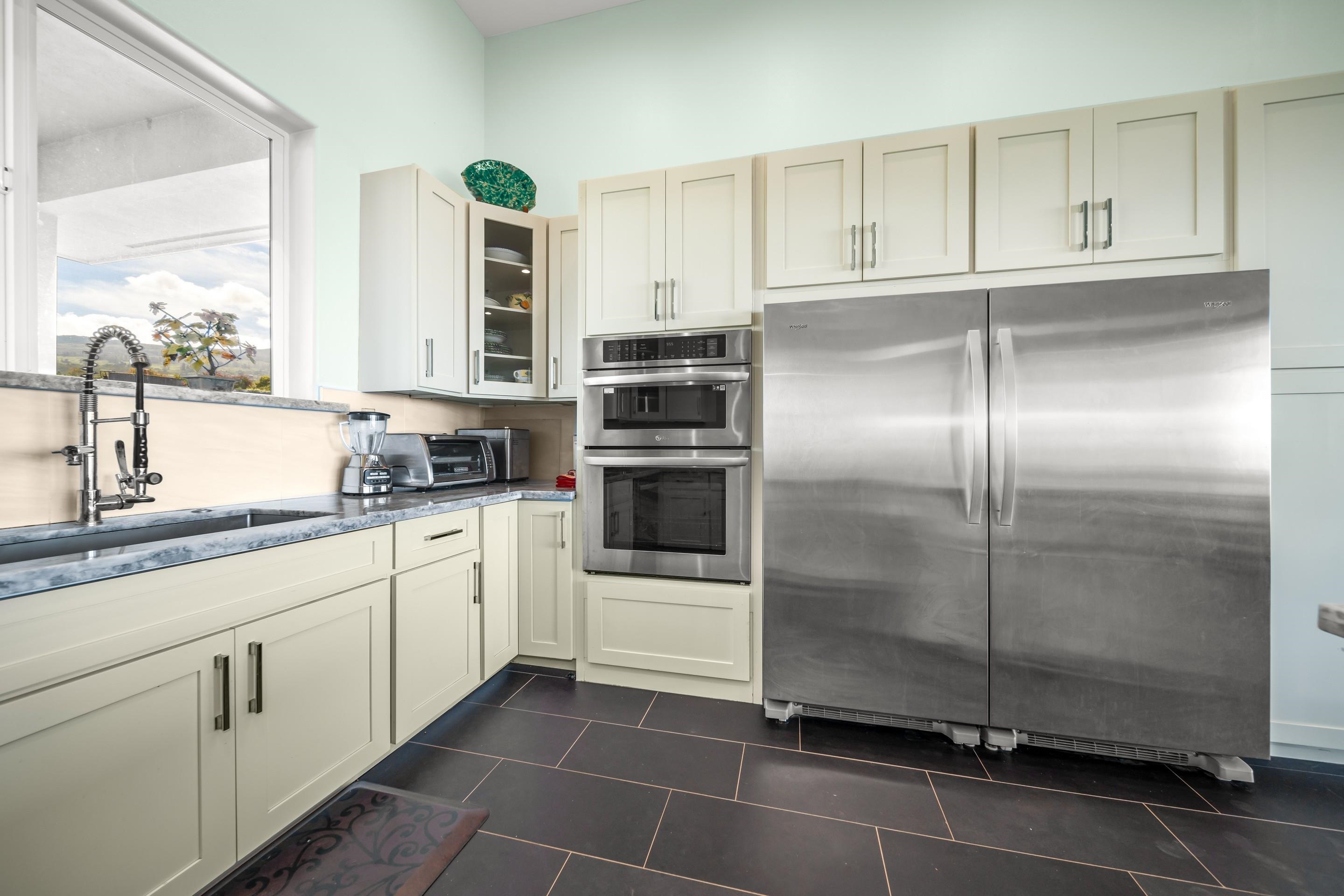 272 Huahua Street Kula, HI 96790 - Photo 14 of 43 a kitchen with a refrigerator a sink and cabinets