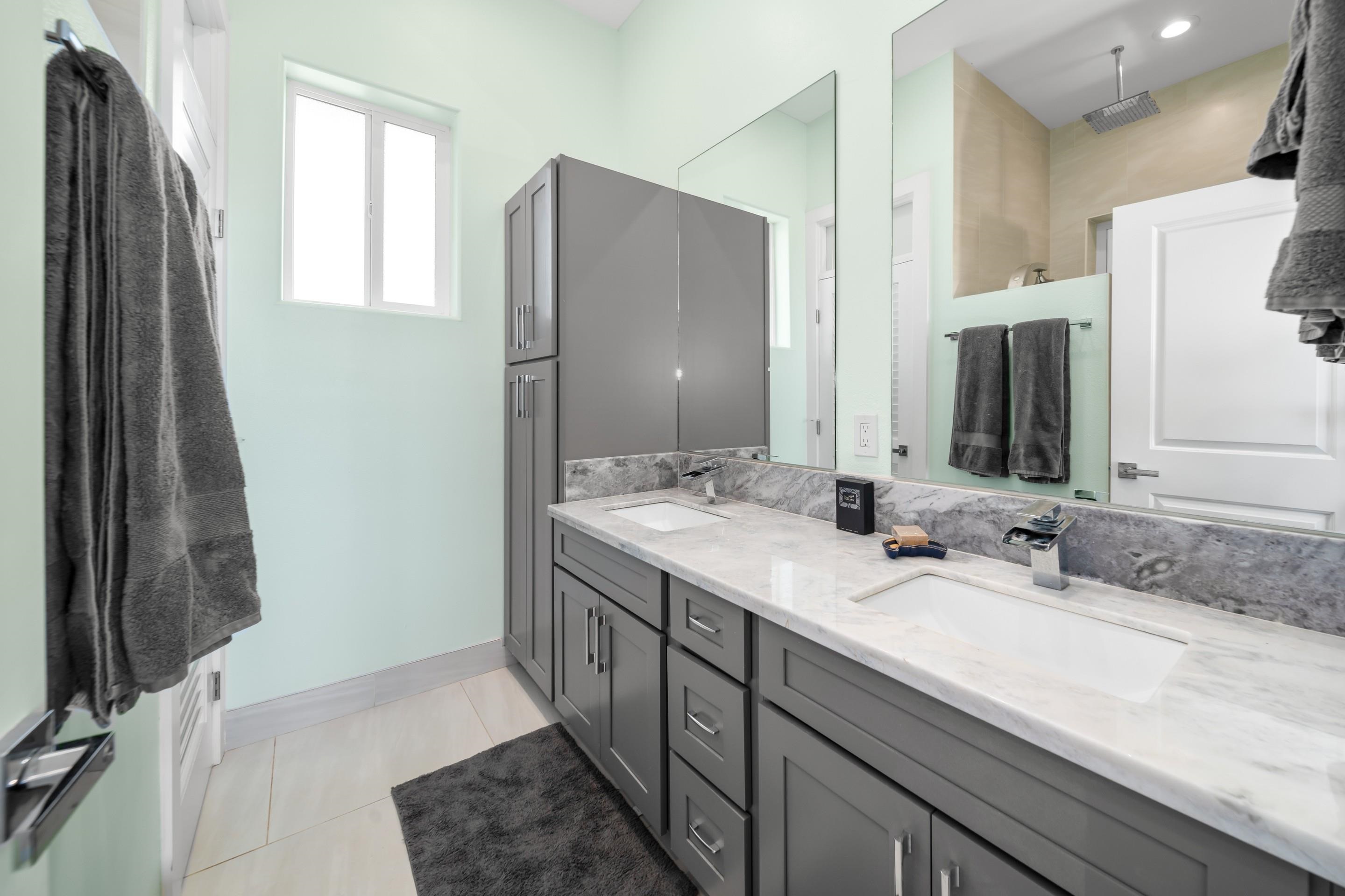 272 Huahua Street Kula, HI 96790 - Photo 22 of 43 a bathroom with a double vanity sink and mirror