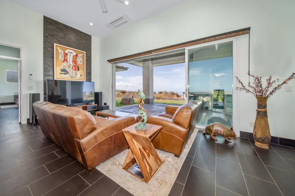 a living room with furniture a floor to ceiling window and a flat screen tv