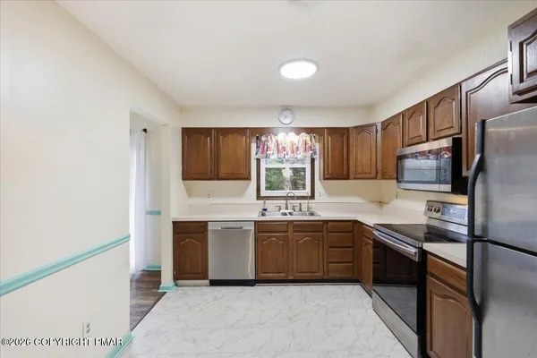 a kitchen with stainless steel appliances granite countertop a sink and stove top oven