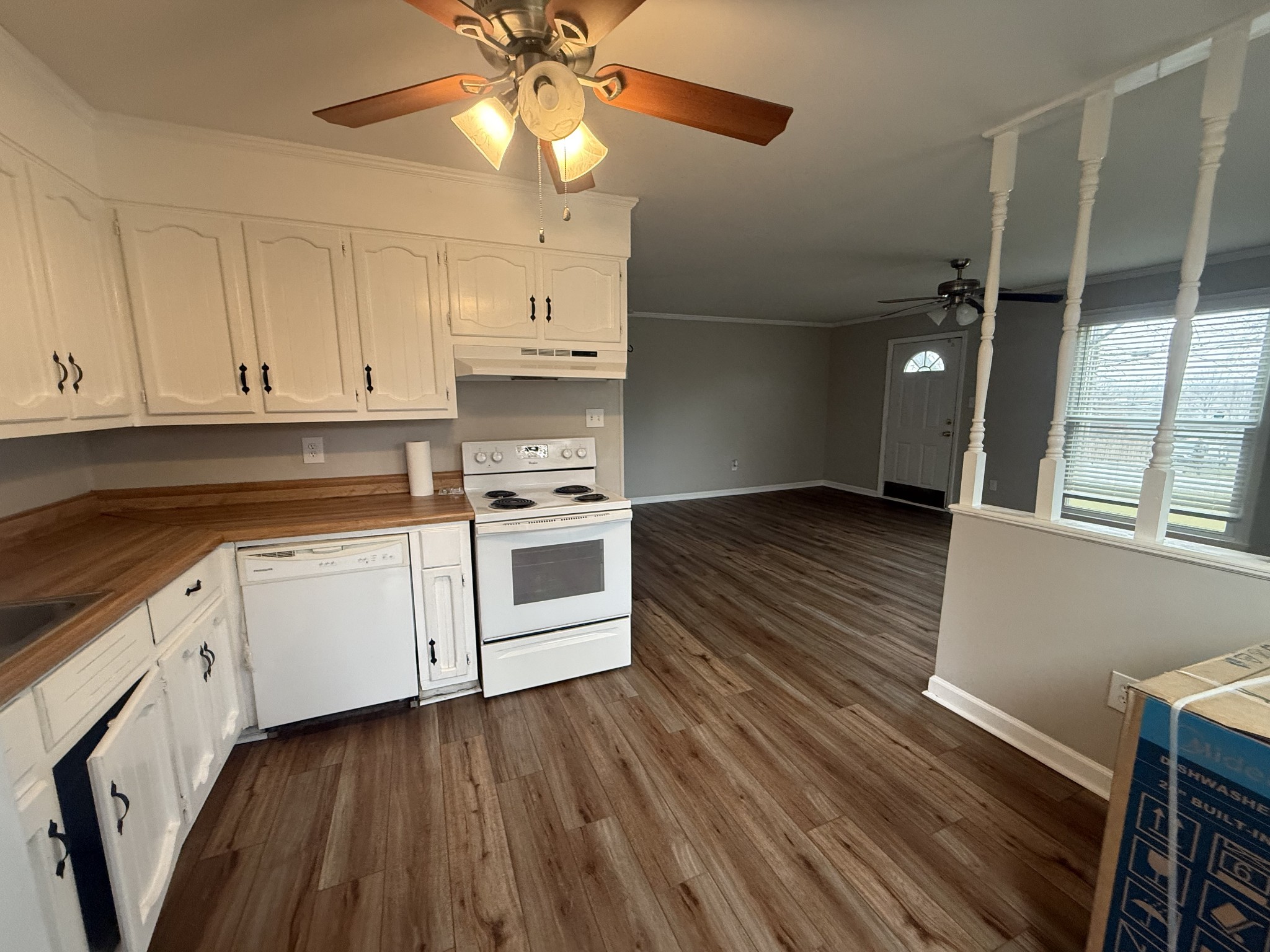 a kitchen with granite countertop a stove cabinets and wooden floor