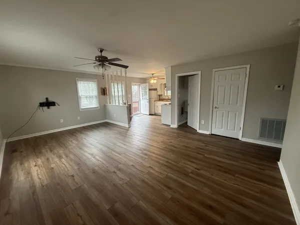 an empty room with wooden floor and windows