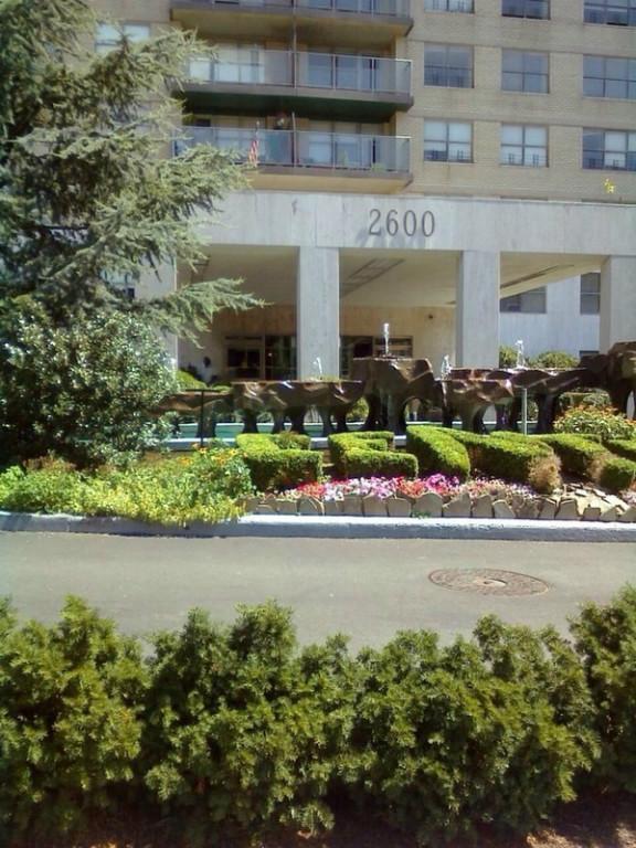 front view of a building with a garden and plants