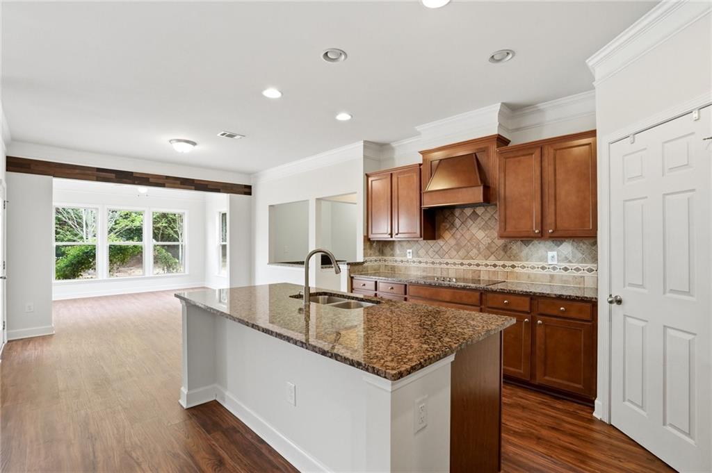 3770 Terrasol Trail Southwest Lilburn, GA 30047 - Photo 11 of 63 a kitchen with stainless steel appliances granite countertop a sink a stove and a wooden floors