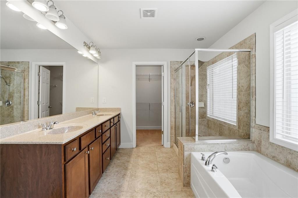 3770 Terrasol Trail Southwest Lilburn, GA 30047 - Photo 23 of 63 a spacious bathroom with a tub sink shower and mirror