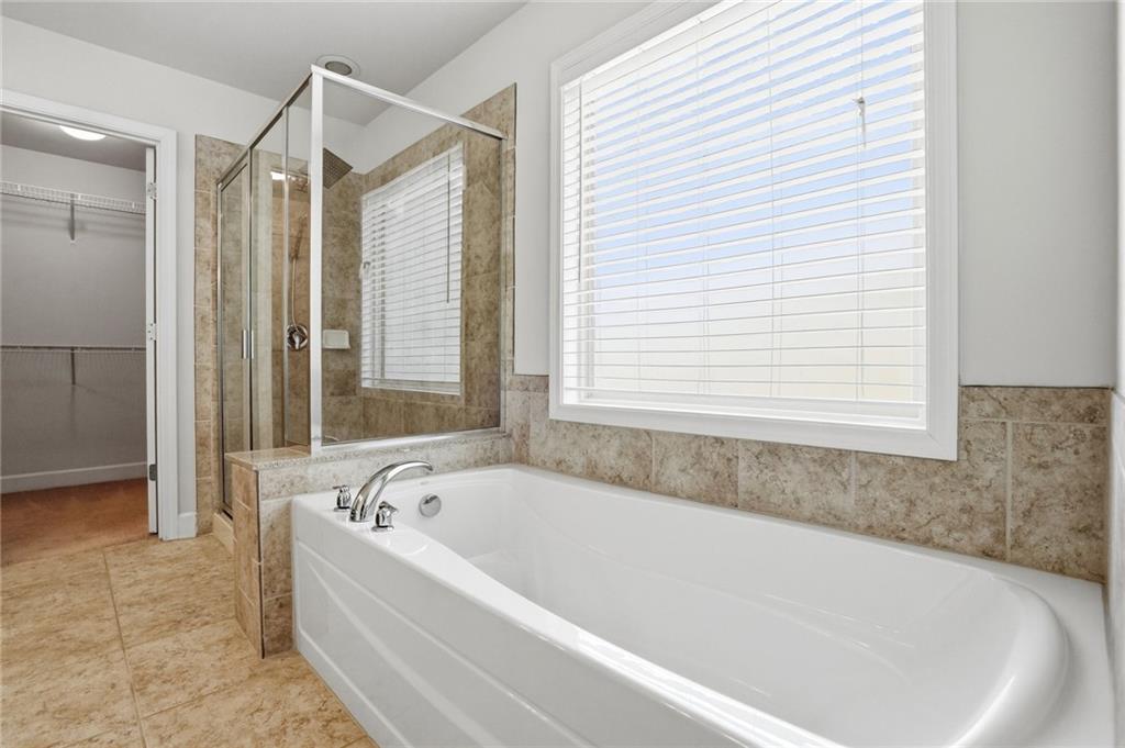 3770 Terrasol Trail Southwest Lilburn, GA 30047 - Photo 24 of 63 a white bath tub sitting in a bathroom next to a window