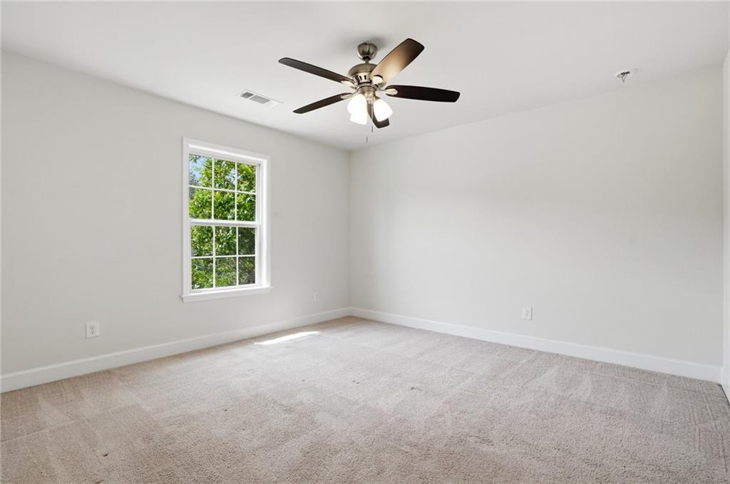 3770 Terrasol Trail Southwest Lilburn, GA 30047 - Photo 31 of 63 an empty room with a window and a ceiling fan