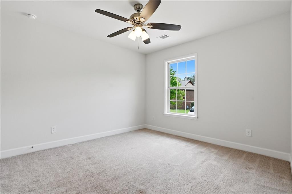 3770 Terrasol Trail Southwest Lilburn, GA 30047 - Photo 35 of 63 an empty room with windows and fan