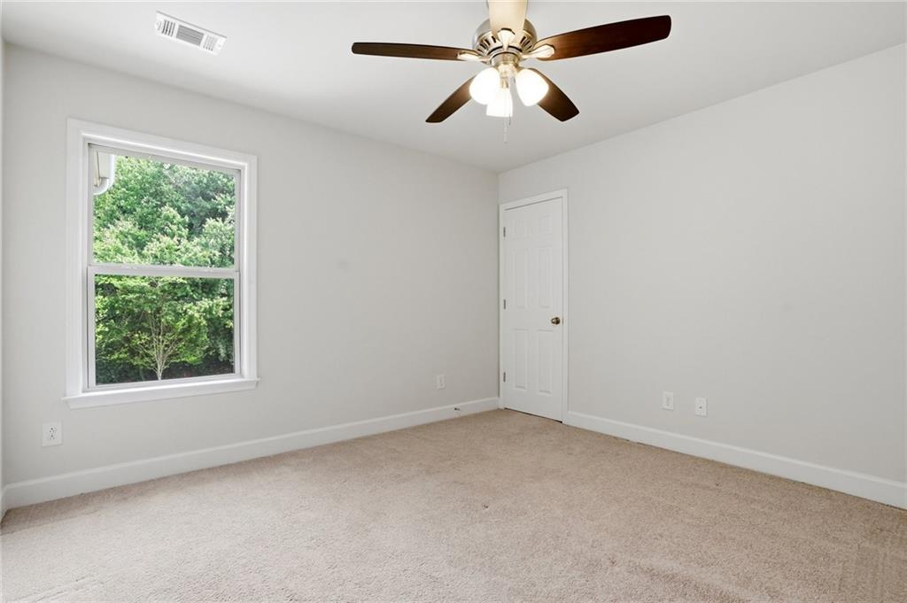 3770 Terrasol Trail Southwest Lilburn, GA 30047 - Photo 36 of 63 an empty room with a window and a fan