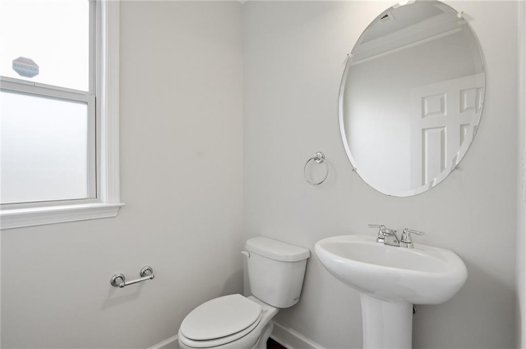 3770 Terrasol Trail Southwest Lilburn, GA 30047 - Photo 39 of 63 a bathroom with a sink a mirror and a toilet