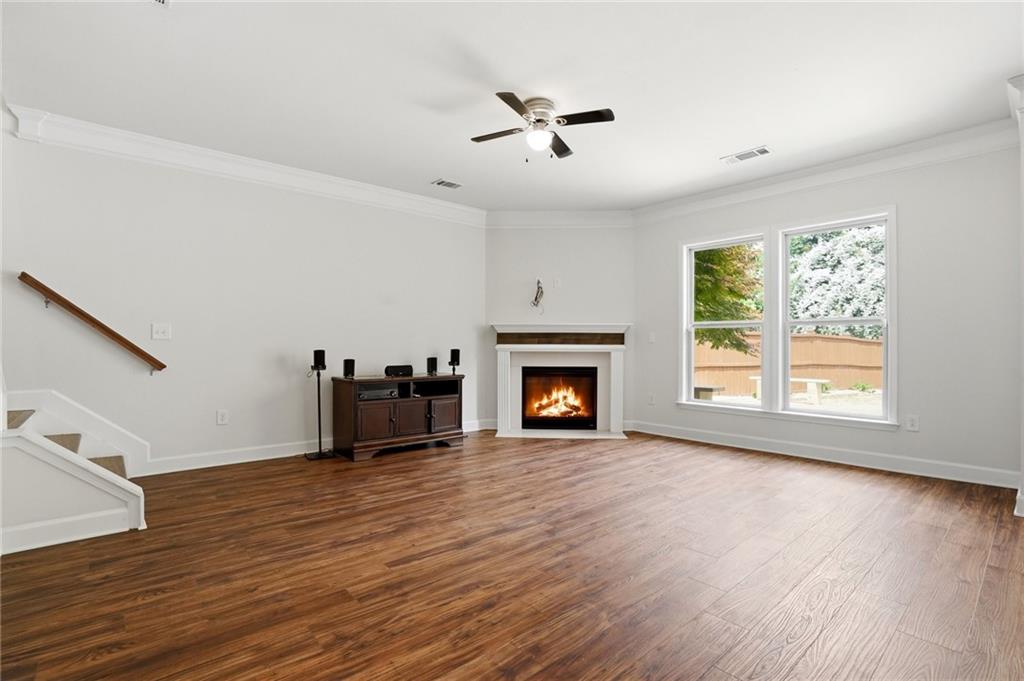 3770 Terrasol Trail Southwest Lilburn, GA 30047 - Photo 5 of 63 an empty room with windows fireplace and wooden floor