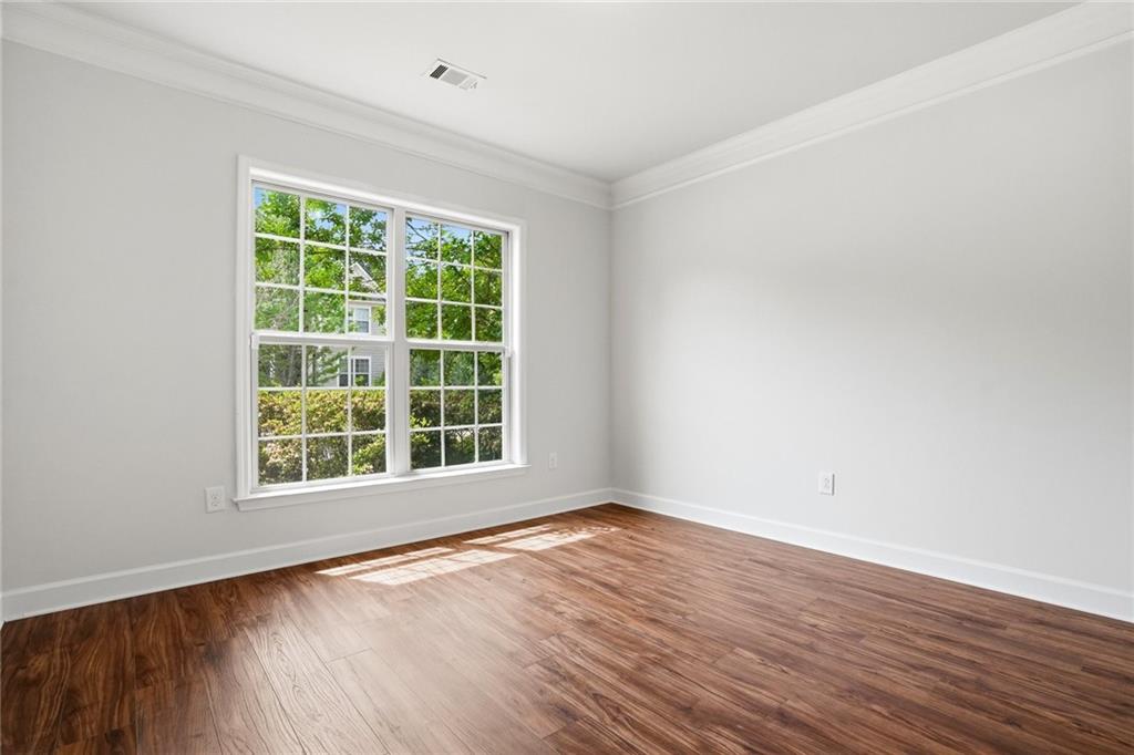 3770 Terrasol Trail Southwest Lilburn, GA 30047 - Photo 10 of 63 a view of an empty room with wooden floor and a window