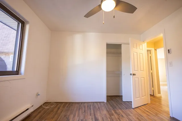 a view of a room with wooden floor and a window