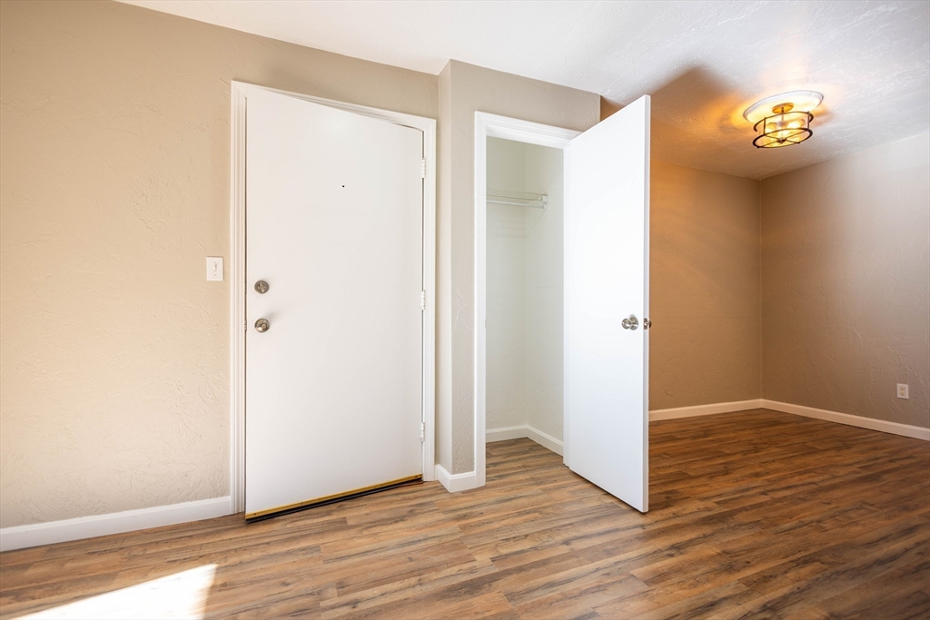 21 Erick Road, Unit 16 Mansfield, MA 02048 - Photo 19 of 28 an empty room with wooden floor and windows