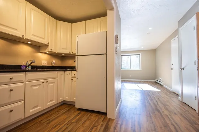 a kitchen with granite countertop white cabinets and white appliances