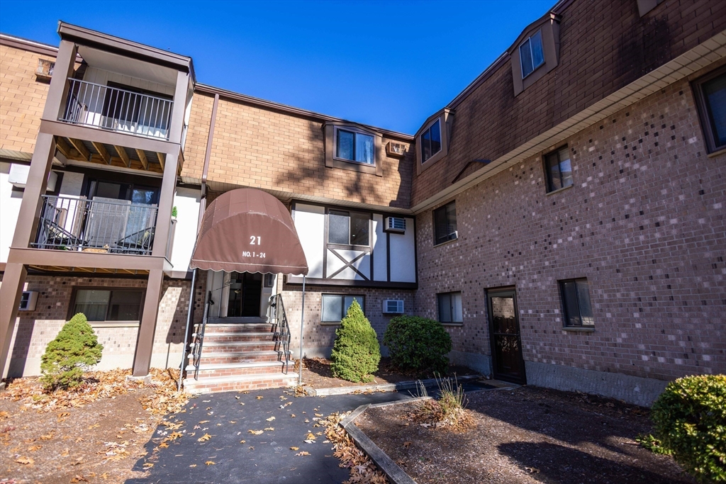21 Erick Road, Unit 16 Mansfield, MA 02048 - Photo 26 of 28 a front view of a residential apartment building with a yard