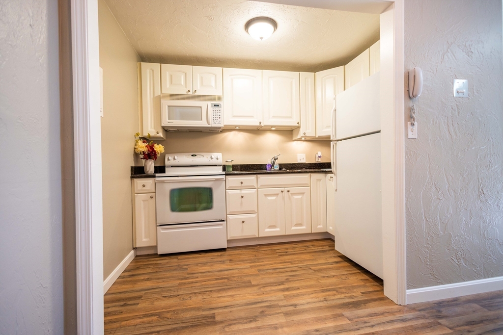 21 Erick Road, Unit 16 Mansfield, MA 02048 - Photo 3 of 28 a kitchen with a stove sink and cabinets